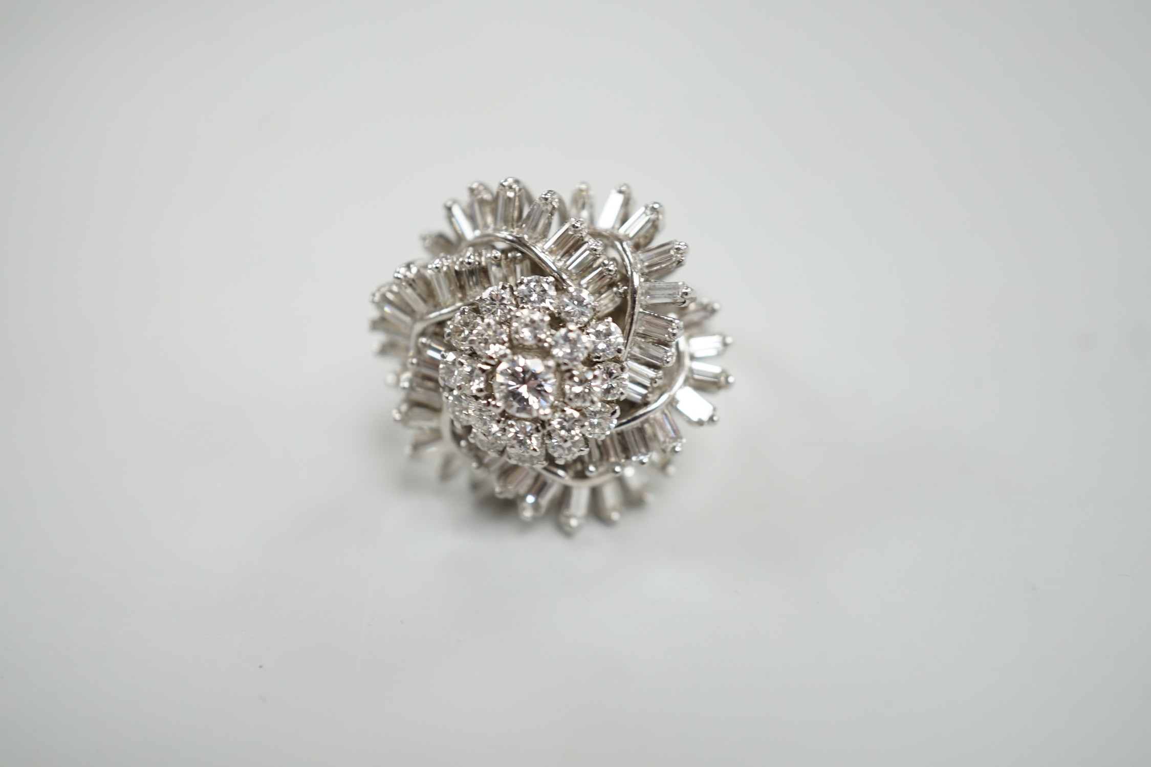 A white metal, baguette and round cut diamond spiral cluster set dress ring, size P, gross weight 14.7 grams.